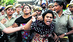 Women protesters being frisked away by the police in the Daba area