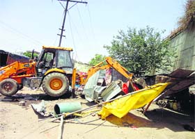 A JCB machine uproots an illegal kiosk in Phagwara on Thursday
