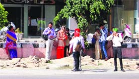 Commuters wait for the bus at a bus stop in Amritsar on Friday.