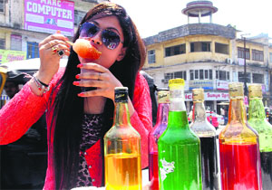 A girl licks ice-candy in Dehradun's Cannuaght Place area on Friday.