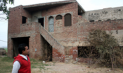 Victim Jassis husband in front of the house where she was found stabbed to death in a Malerkotla village