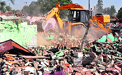 An earthmover razes structures at Nehru Colony in Sector 52