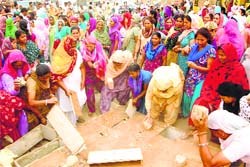 Women smash the furniture of a liquor vend on the Begu road in Sirsa on Saturday. Tribune photo