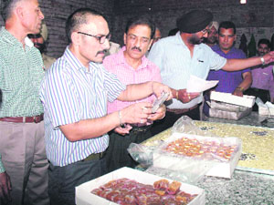 Members of the Health Department during a raid on a sweets shop in Jalandhar on Saturday.