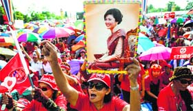 A member of the pro-government Red Shirt group holds a picture of ousted PM Yingluck Shinawatra during a rally on the outskirts of Bangkok on Saturday.