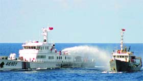 A Chinese coastguard vessel (left) uses a water cannon on a Vietnamese Sea Guard ship on the South China Sea.