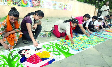 Artists and members of Health Education and Environment Awareness Society make a painting on the occasion of International Mothers Day at Jantar Mantar in New Delhi on Sunday. 