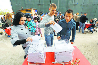 People cast ballots at a polling station during the referendum on the status of Donetsk and Luhansk regions on Sunday