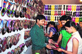 Visitors buy juttis on the last day of the Pakistani exhibition at Trillium Mall in Amritsar on Monday
