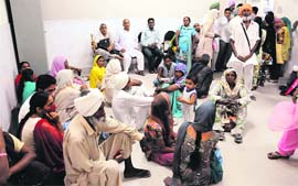 Patients sit on the floor of the OPD at the Civil Hospital in Bathinda on Monday.