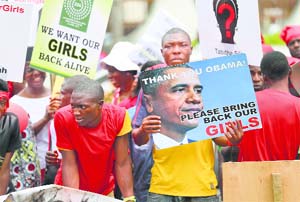 People carry signs as they attend a protest demanding the release of abducted secondary school girls from Chibok. Reuters