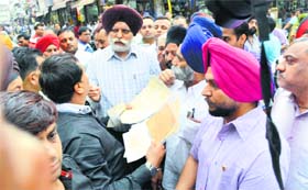 Mayor Harcharan Singh Gohalwaria argues with shopkeepers at Chaura Bazar in Ludhiana on Monday