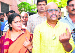 Congress candidate Ajai Rai, with a badge of the party symbol pinned on his kurta, along with his family at a polling booth in Varanasi on Monday.