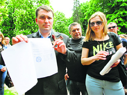 Alexander Malykhin (L), head of a local election committee, holds up a sheet of paper that shows the results of the referendum on the status of Luhansk region, in Luhansk on Monday