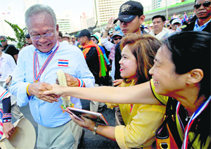 Thai anti-government protest leader Suthep Thaugsuban (L) with his supporters during a rally in Bangkok on Monday