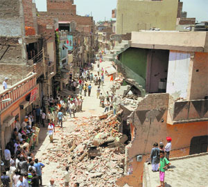 Onlookers at two houses in the Jagirpur area, near Basti Jodhwal, where extended portions were demolished on Tuesday.