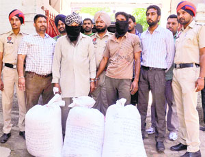 The suspects, along with two quintals of seized poppy husk, in police custody in Ludhiana on Monday.