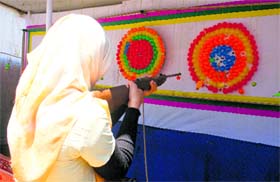 Focused: A girl aims the air gun at balloons at a fair in Kashmir on Wednesday