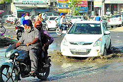 Vehicles pass through a waterlogged road in Khanna