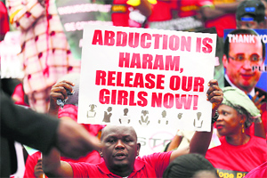 A man holds a placard calling for the release of girls during a protest along a road in Lagos on Wednesday