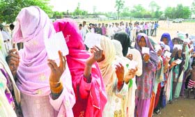 People queue up at a polling centre to cast votes during a repoll in Mewat on Thursday.