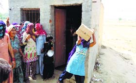 Women throw liqour stock out of a liquor vend in Bhonsla village of Jind on Thursday.