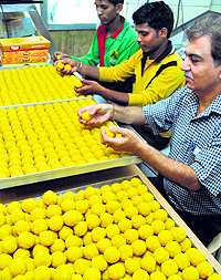 Workers busy preparing laddoos at a sweets shop in Patiala on Thursday