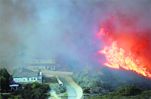 A wildfire approaches homes at San Marcos in California on Thursday. Flames engulfed suburban homes and shot up along canyon ridges in one of the worst of several blazes that broke out on Wednesday in Southern California. 