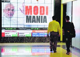 People walk in front of the screen inside the Bombay Stock Exchange in Mumbai on Friday