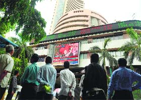 Pedestrians watch as a digital broadcast presents the rolling share price information and national election result news coverage on the facade of the BSE building on Friday