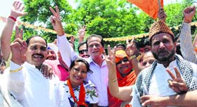 BJP leader Harmohan Dhawan (centre) and party activists flash the victory sign at the party office in Chandigarh on Friday.