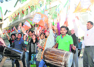 BJP supporters dance as poll results come in at the party headquarters in Shimla on Friday.