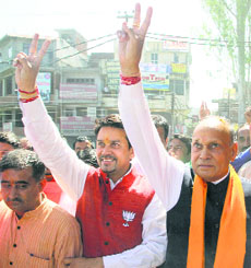 Anurag Thakur and ex-Chief Minister PK Dhumal make the victory sign after election results in Hamirpur on Friday.