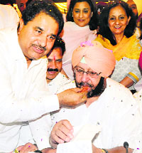 A Congress worker offers sweets to Capt Amarinder Singh in Amritsar on Friday. 