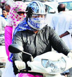 Two young girls cover their faces to escape the heat in Gurgaon.