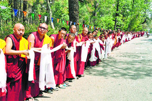 Tibetans-in-exile stand with ceremonial scarves and incense sticks to welcome the Dalai Lama from Europe in Dharamsala on Saturday.