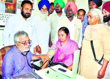 Newly elected MP Dr Dharamvir Gandhi examines a patient at his clinic after two-month-long hectic poll campaign, in Patiala on Saturday. Gandhi was attacked allegedly by Akali leaders on the day of polling on April 30.
