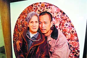 This picture shows a photo of Chinese artist He Yunchang (R) and his mother wearing a necklace He Yunchang made during his project "One Rib", with one of his ribs in his studio in Beijing