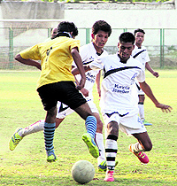 Players fight it out in a match during the Dehradun District Football League being played at the Pavilion Ground in Dehradun on Sunday