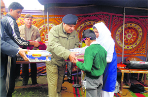 Aafad-ul-Mujtaba, DIG, central Kashmir range, distributes study material among differently abled children in Srinagar on Sunday.