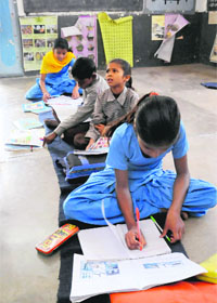 Students of Government Primary School at Central Jail in Bathinda study on the floor in the absence of any furniture.