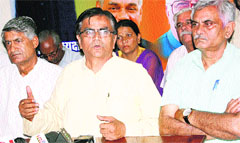 BJP Kisan Morcha president Om Prakash Dhankar (centre) addresses a news conference at Rohtak on Monday. A Tribune photograph
