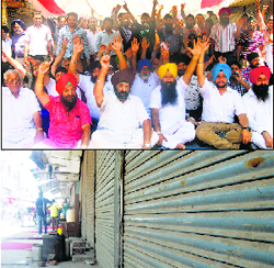 Shopkeepers shout slogans outside the office of Punjab State Power Corporation Limited; and shops closed at Chaura Bazar in Ludhiana on Monday. 