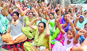 Anganwadi workers protest outside the Deputy Commissioners office in Ludhiana on Monday.
