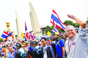 Anti-government protest leader Suthep Thaugsuban (right) gestures as he leads a march in Bangkok on Monday.