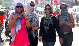 Girls protect themselves against the scorching heat in Dehradun on Tuesday.