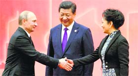Russian President Vladimir Putin (L) greets Chinese First Lady Peng Liyuan as Chinese President Xi Jinping looks on in Shanghai.