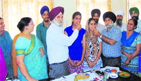Students of Shri Guru Harkrishan Public School being offered sweets by their teachers in Amritsar