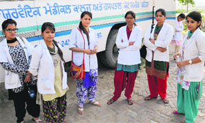 Students of Saint Sahara Ayurvedic Medical School wait to be ferried to their college in Bathinda on Wednesday.