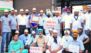 AAP workers stage a silent protest against the arrest of Arvind Kejriwal, in Bathinda on Wednesday.